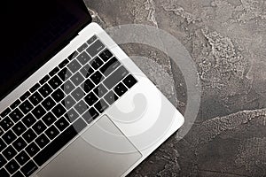 Top view of laptop with black keyboard on black texture background.