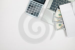 Top view of laptop and calculator with dollars on white background