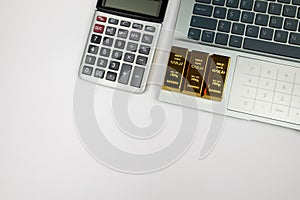 Top view of laptop calculator and gold bars with copy space