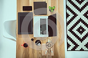 top view of laptop with graphics tablet and smartphone on wooden tabletop photo