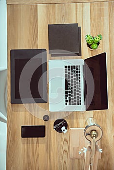 top view of laptop with graphics tablet and smartphone on wooden tabletop photo