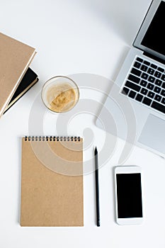 Top view of laptop, smartphone, notepad, books and glass of coffee
