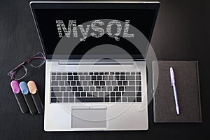 Top view of laptop with text MySQL. MySQL inscription on laptop screen and keyboard. Learn MySQL language, computer courses,