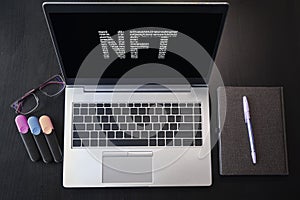 Top view of laptop with text NFT. Non-fungible token