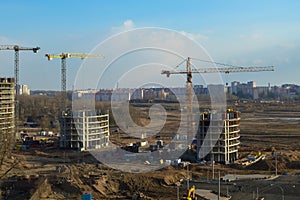 Top view of a large construction site with cranes and buildings houses concrete monolithic frame panel multi-storey