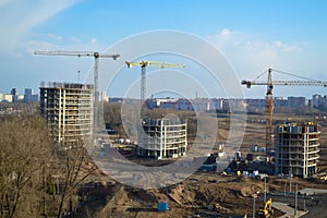 Top view of a large construction site with cranes and buildings houses concrete monolithic frame panel multi-storey