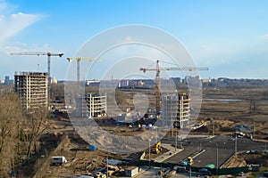 Top view of a large construction site with cranes and buildings houses concrete monolithic frame panel multi-storey