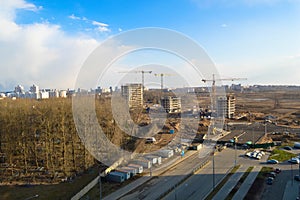 Top view of a large construction site with cranes and buildings houses concrete monolithic frame panel multi-storey