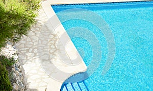 Top View of Large Mansion Villa Pool with Blue Turquoise Water on Sunny Summer Day. Vegetation Pine Trees Stone Deck