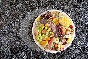 Top view large tray of sliced assorted fresh tropical fruits platter on grey background