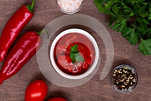 Lecho of tomatoes and sweet paprika with ingredients on the table