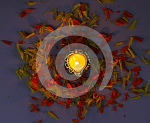 A top view of lit diya and flowers to celebrate diwali and dhanteras