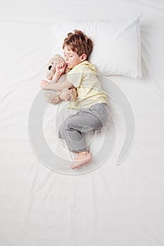 Top view of little boy sleeping in Foetus pose