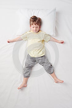 Top view of little boy sleeping in Star pose