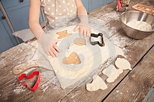 Top view of little child girl helping her mother in the kitchen to make cookies. making different shapes of cookies on