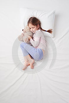 Top view of little cute girl sleeping with teddy