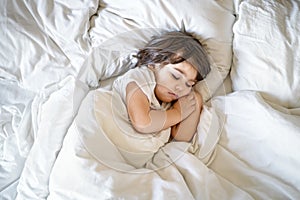 Top view of little toddler boy sleeping peacefully in bed