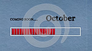 Top view of loading bar with text - Coming soon October. Light blue background.