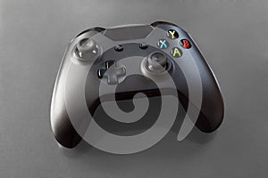 Top view of a logo free, black videogame controller on grey background