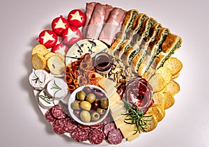 Top view of lunch or appetiser with a dish with salami, pepperoni, brie cheese, ham. Aerial view of one plat: meal composed by photo