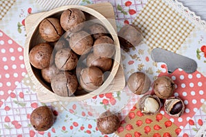 Top view macadamia on napery and wooden bowl