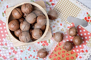 Top view macadamia on napery and wooden bowl