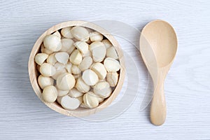 Top view macadamia nuts and shell in wooden bowl