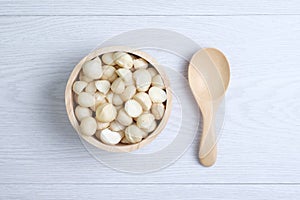 Top view macadamia nuts and shell in wooden bowl