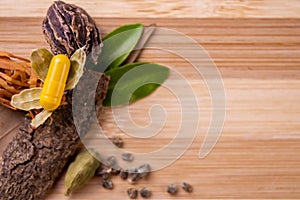 Top view macro shot of herbal pills and tablets arranged with spices on a red stone. Unani medicines concept