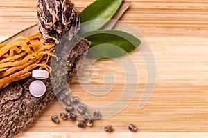 Top view macro shot of herbal pills and tablets arranged with spices on a red stone. Unani medicines concept