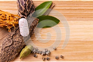 Top view macro shot of herbal pills and tablets arranged with spices on a red stone. Unani medicines concept