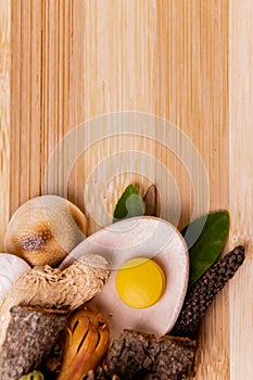 Top view macro shot of herbal pills and tablets arranged with spices on a red stone. Unani medicines concept