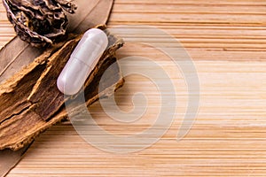 Top view macro shot of herbal pills and tablets arranged with spices on a red stone. Unani medicines concept