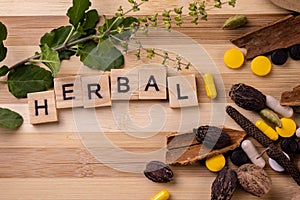 Top view macro shot of herbal pills and tablets arranged with spices on a red stone. Unani medicines concept