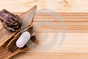 Top view macro shot of herbal pills and tablets arranged with spices on a red stone. Unani medicines concept