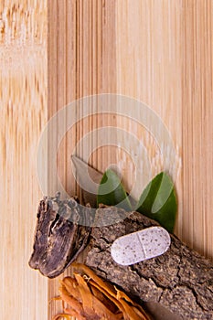 Top view macro shot of herbal pills and tablets arranged with spices on a red stone. Unani medicines concept