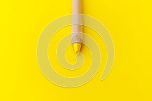 Top view and macro shot of a pencil. Abstract photo with yellow pencil on yellow background for concept design