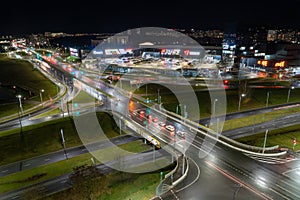 Top view of a major road junction in the city at night. The movement of cars in the night city. Light from vehicles and lanterns