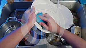 Top view of male hands washing dishes in the kitchen.