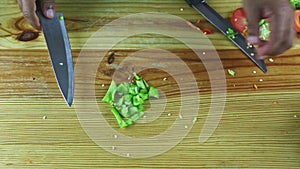 Top view on man hands cut by knife on pieces large green pepper slices