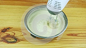 top view man hands by electric mixer start mixing white liquid dough in metal saucepan