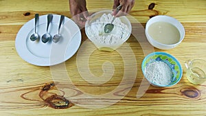 Top view on man hands making deepening by spoon in white flour served in bowl