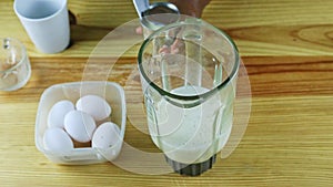 Top view on man hands open metal can with condensed milk next to blender chalice