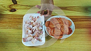 Top view on man by hands put plate with chopped ham next to paperoni slices