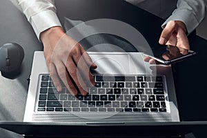 Top view of man hands typing on laptop and smartphone ,  surfing the internet or online working . business and technology