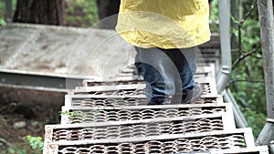 Top view of a man hiker going down the metal stairs in the forest. Stock footage. Close up of traveler legs on the path
