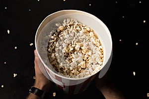 top view of man holding bucket of popcorn