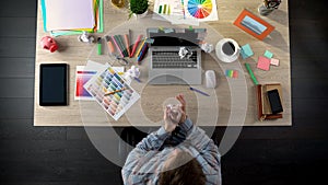 Top view of man looking for startup ideas, writing on paper and crumpling it