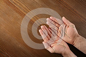 Top view of man showing palms with drawn lines on wooden background. Chiromancy and foretelling photo