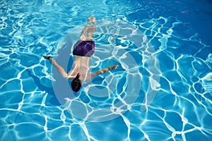 Top view of a man swimming in a swimming pool on sunny summer day